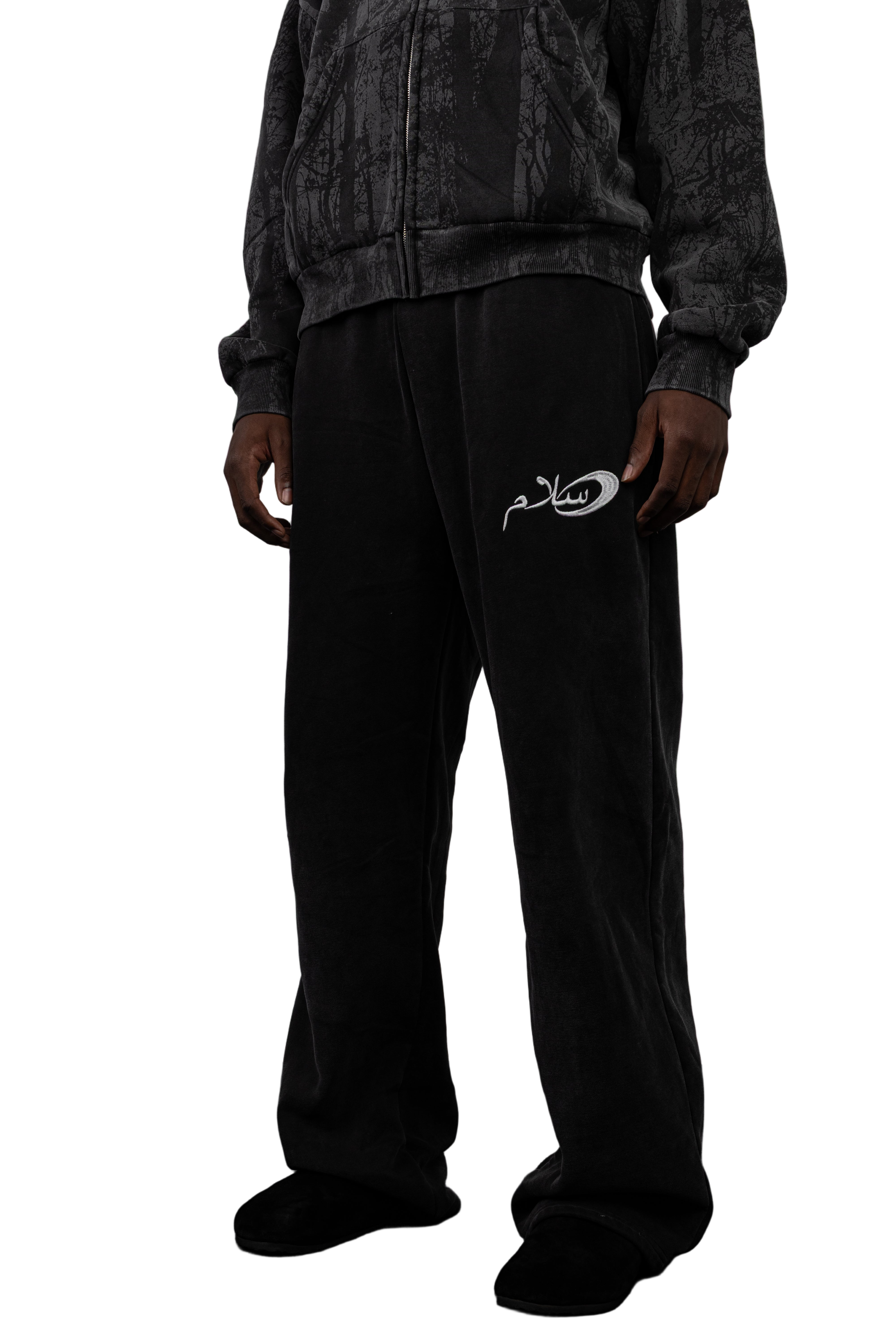 Person wearing Salaam black pants with Salaam logo 